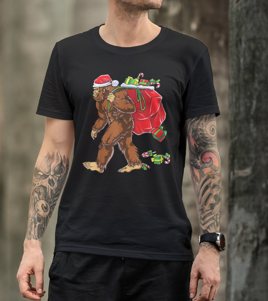 Bigfoot Santa With Giant Red Christmas Bag And Green Gifts Wearing Xmas Hat T-Shirt