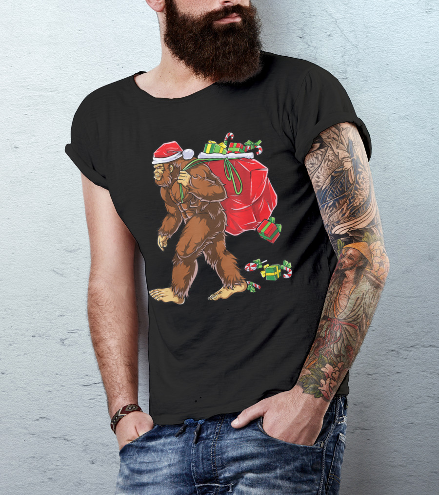 Bigfoot Santa With Giant Red Christmas Bag And Green Gifts Wearing Xmas Hat T-Shirt
