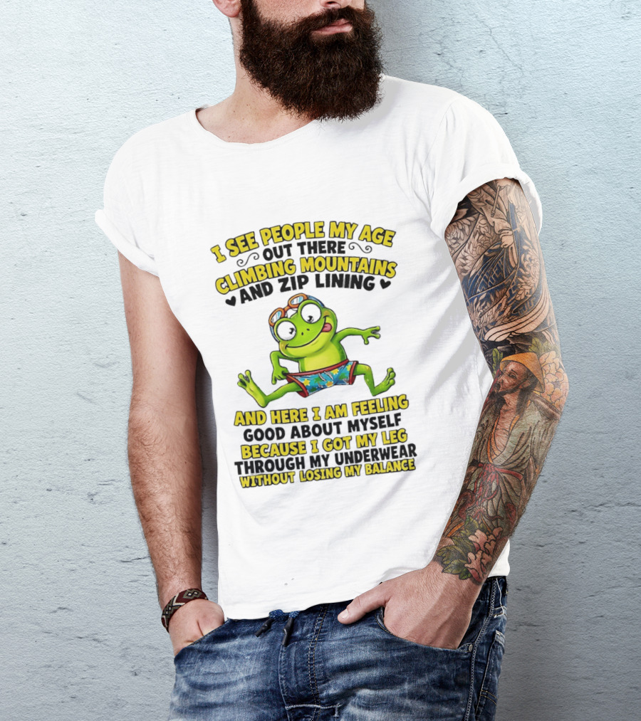 I See People My Age Climbing Mountains And Zip Lining Cartoon Frog Feeling Good Without Losing Balance T-Shirt