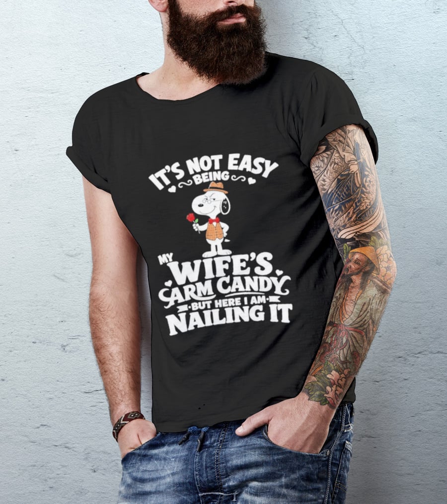 Snoopy It's Not Easy Being My Wife's Arm Candy But Here I Am Nailing It T-Shirt