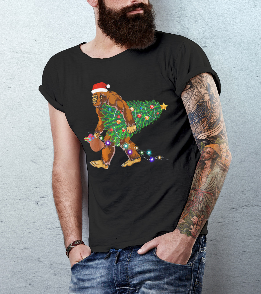 Santa Hat Bigfoot Holding Christmas Tree With Lights And Gifts T-Shirt